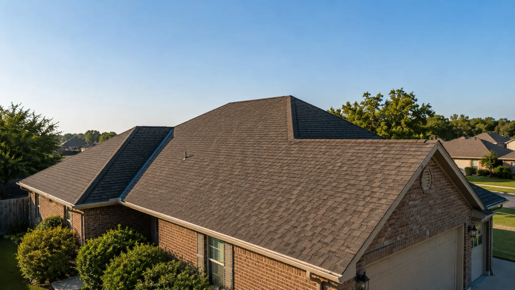 Residential shingle roof beneath a blue sky